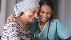 Healthcare worker embracing patient with head wrap