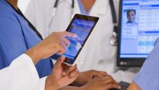 Healthcare workers looking at a medical record on a tablet